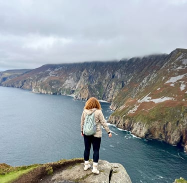 A hiker overlooks the Slieve League cliffs and Atlantic Ocean in County Donegal, Ireland.