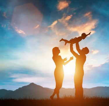 Familia en el firmamento con un niño en brazos