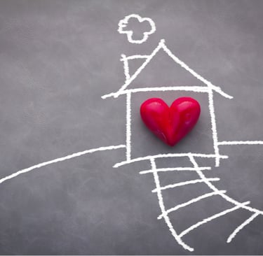 Dibujo con gis de una casa con un corazón rojo