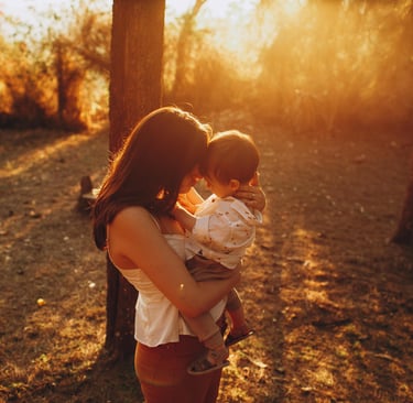 Mamà abrazando a su hijo pequeño en medio del bosque