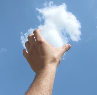 Mano levantada simulando tocar una nube en el cielo azul