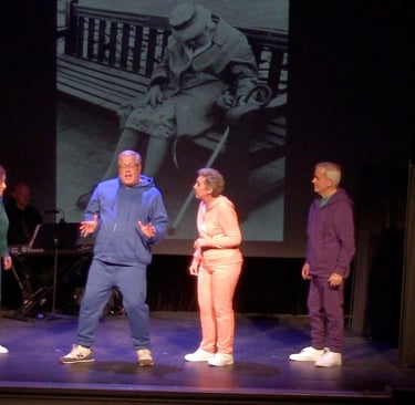 Senior actors performing a stage play in colorful tracksuits with a vintage photo backdrop.