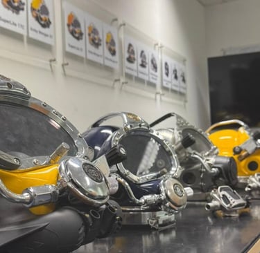 Professional Kirby Morgan commercial diving helmets displayed on a table for equipment training.