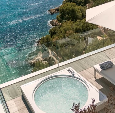 Luxury terrace with a private hot tub and sun loungers overlooking the turquoise Mediterranean Sea.