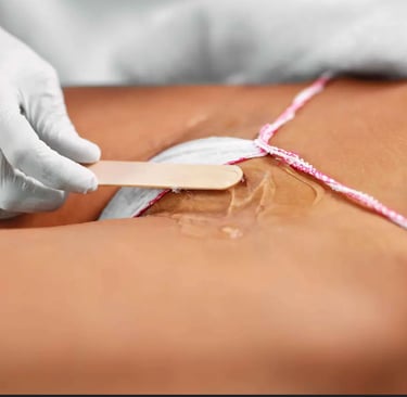 Professional aesthetician applying wax for hair removal treatment on the bikini line