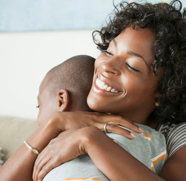 a woman is hugging her baby and smiling