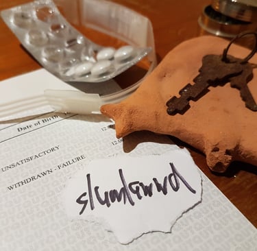 slumlawwd written on scrap paper on a desk, next to keys, a failed exam report and medication