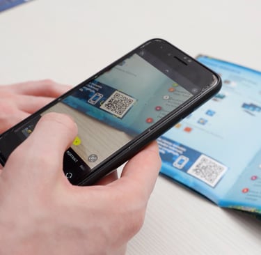 Telefonu skenuojamas QR kodas nuo žaidimo taisyklių knygelės