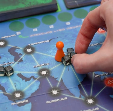 Ranka nuima ligų kubelius nuo stalo žaidimo lentos