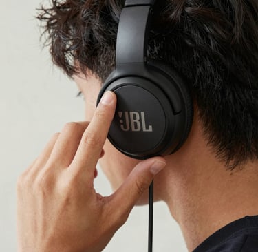a man wearing headphones standing in front of a sign