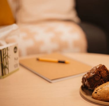 A welcoming coffee table with biscuits, notebook, pen and tissues, details that make clients feel at home.