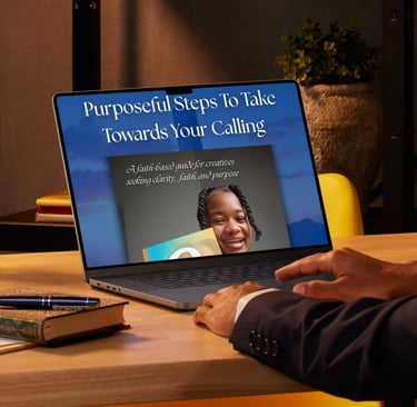 A laptop on a wooden desk displaying a faith-based guide for creatives seeking purpose and calling.