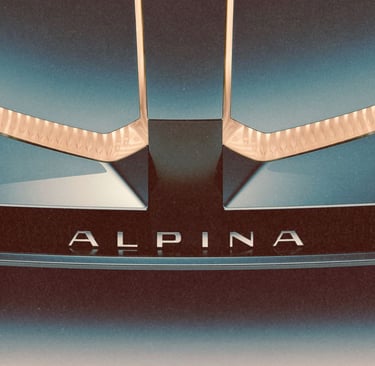 Close-up of a luxury Alpina car front bumper featuring silver lettering and elegant gold trim accents.