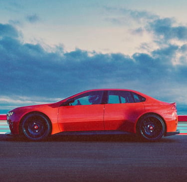 Side profile of a red high-performance sports sedan racing on a track under a cloudy sky.