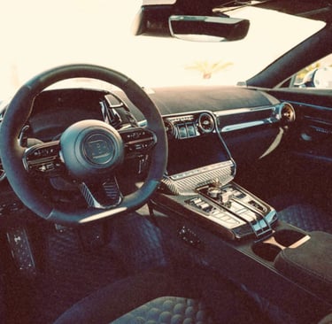 Luxury Brabus car interior featuring a carbon fiber dashboard, Alcantara steering wheel, and premium leather seats.