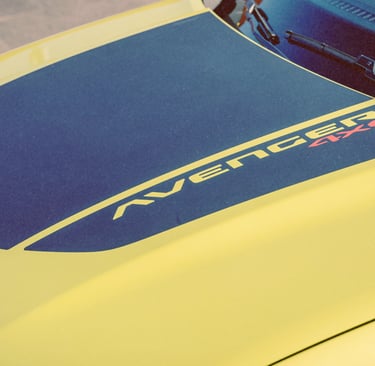 A close-up of a yellow Jeep Avenger 4xe hood featuring a matte black anti-glare decal.
