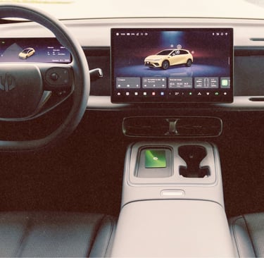 Modern electric vehicle interior featuring a digital cockpit, steering wheel, and large infotainment touchscreen display.