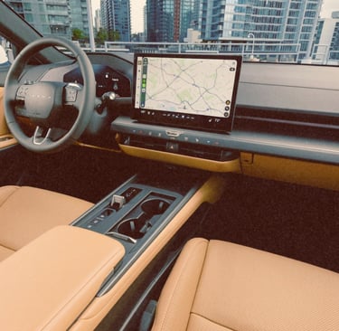 Luxury car interior with tan leather seats and a digital touchscreen navigation display.