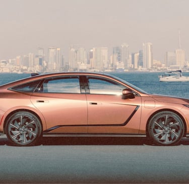 lexus es metallic bronze sedan parked on a coastal road with a city skyline and ocean background.