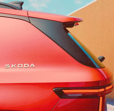 Rear view of a red Skoda SUV showing the silver brand logo and modern LED taillight design.