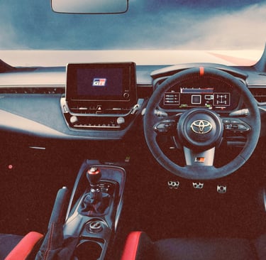 The modern interior of a Toyota GR Corolla featuring a digital dashboard and sporty red accents.