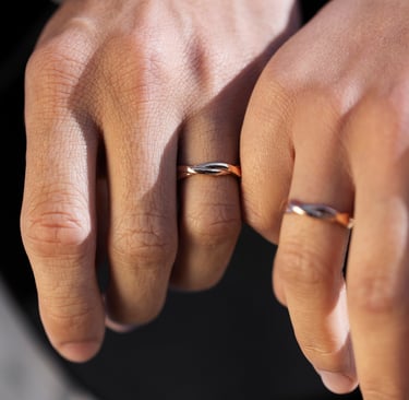 a man and woman's hands holding wedding rings