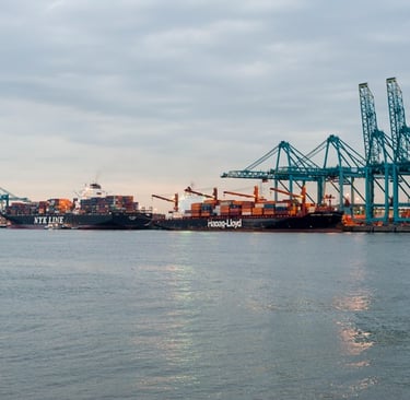 Large cargo container ships docked at a commercial port with industrial cranes for global shipping and logistics.