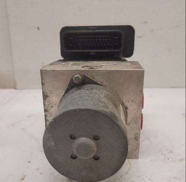 Used automotive ABS control module and hydraulic pump assembly for vehicle brake system repair.