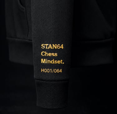 STAN64 Black hoodie sleeve featuring gold embroidered Chess Mindset text and serial number.