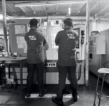 Maquina de mecanizado cnc en las instalaciones de Holimpus SAS con dos trabajadores supervisando