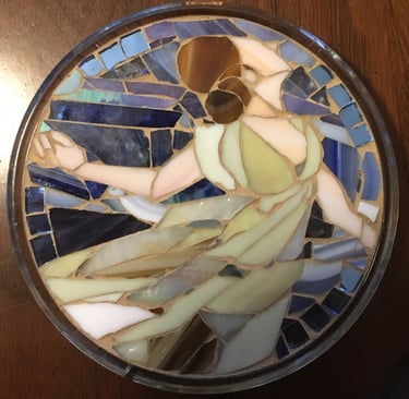 Circular stained glass mosaic titled "Isadora" by Julie Curson, depicting a graceful figure.