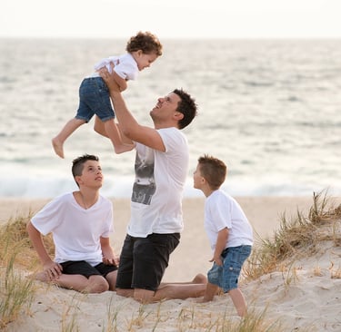 Father plays with sons at City Beach photo by Fisher Photography