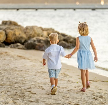 Brother and sister holding hands walking along Point Walter beach at sunset, Perth family photographer Fisher Photography
