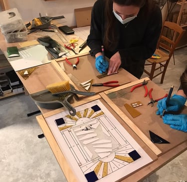 Découpe du verre lors d'un stage d'initiation au vitrail au plomb, atelier Paris 17e
