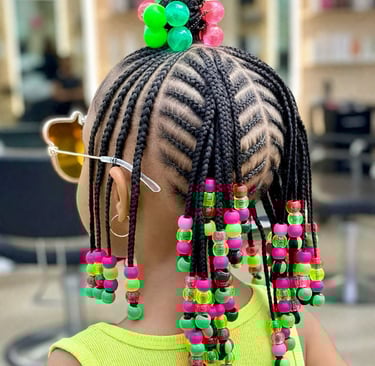 Professional kids hairstyling with braided cornrows and colorful beads in a safe salon environment