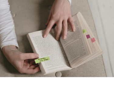 A book with pages marked with colorful sticky tabs