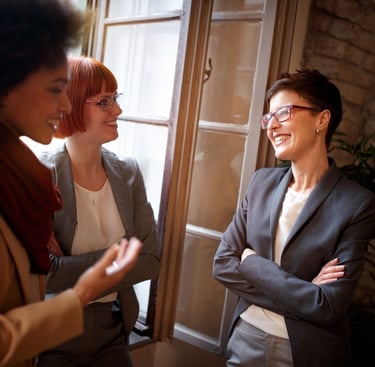 a woman in a suit and glasses talking to a woman