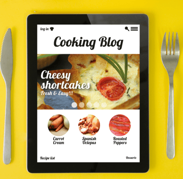 Photo of a tablet between a knife and fork. Tablet says "Cooking Blog"