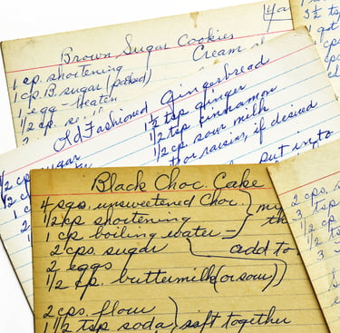 Photo of several yellowed recipe cards with handwritten recipes on them