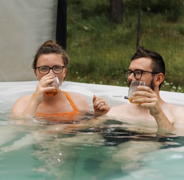 a man and woman in a hot tub drinking whiskey