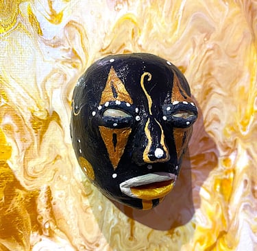 Ilona Paris tableune sculpture noir ressemblant à un masque qui émerge d'un tableau jaune vu de près