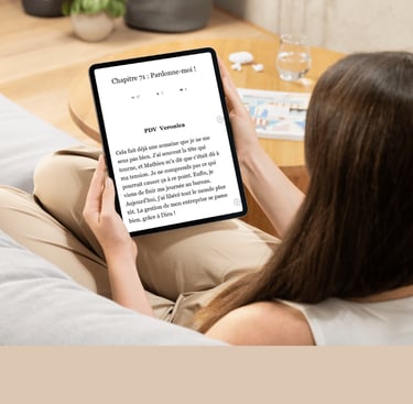 Femme lisant un eBook sur une tablette, confortablement installée.