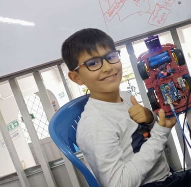 a boy sitting at a desk with a computer mouse