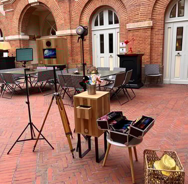 Vintage wooden photo booth with props and lighting on a brick patio event space.