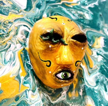 une sculpture sans yeux avec un oeil dans la bouche qui émerge d'une toile verte vu de près