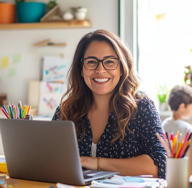 Mamá emprendedora sonríe frente a su laptop, representa creatividad, organización y trabajo desde casa con hijos.