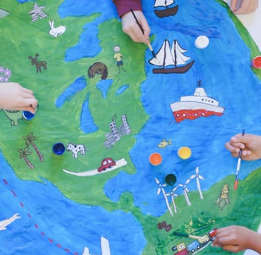a group of children painting a world map mural