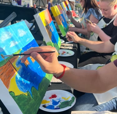 a man is painting on a canvas using a brush and paint palettes