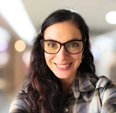 a woman with glasses and a plaid shirt