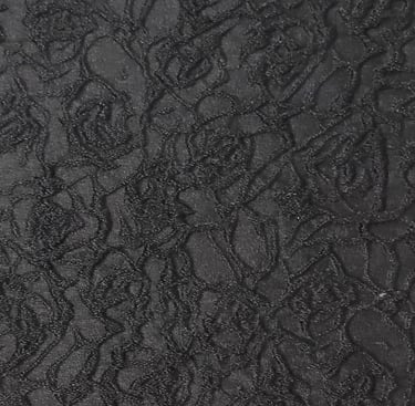 a close-up of a jacquard fabric with black three dimensional  floral patten